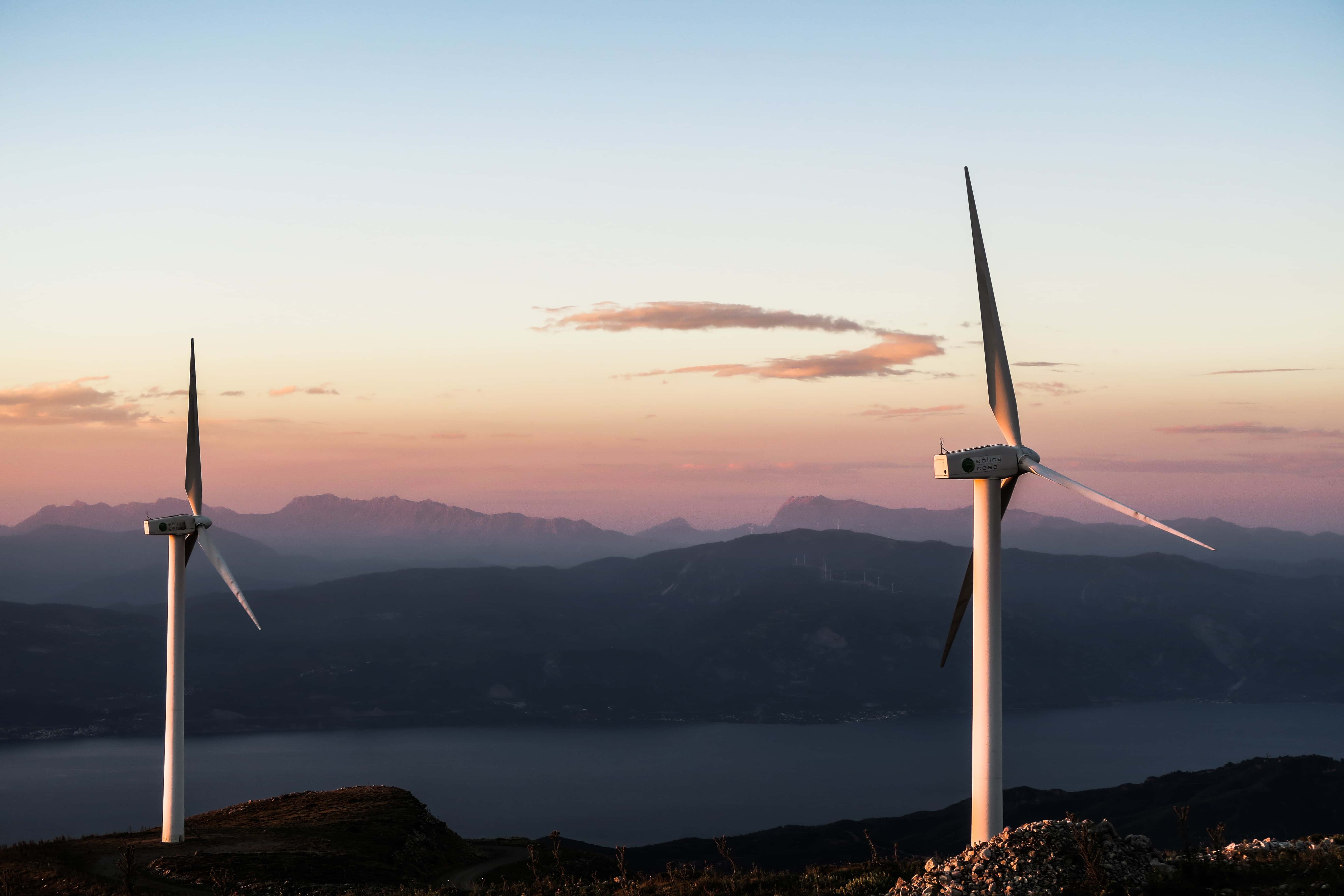Bild zweier Windkraftanlagen im Abendrot