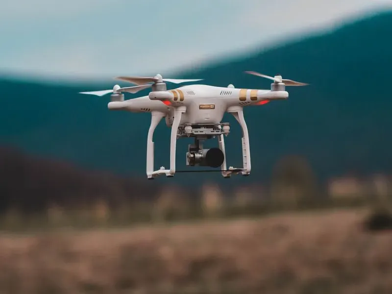 Aufnahme einer fliegenden Drohne mit Kamera vor verblasstem Hintergrund