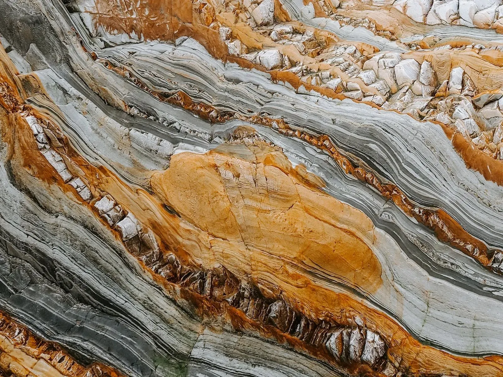 Nahaufnahme von geologischen Gesteinsformationen in Orange und Grau