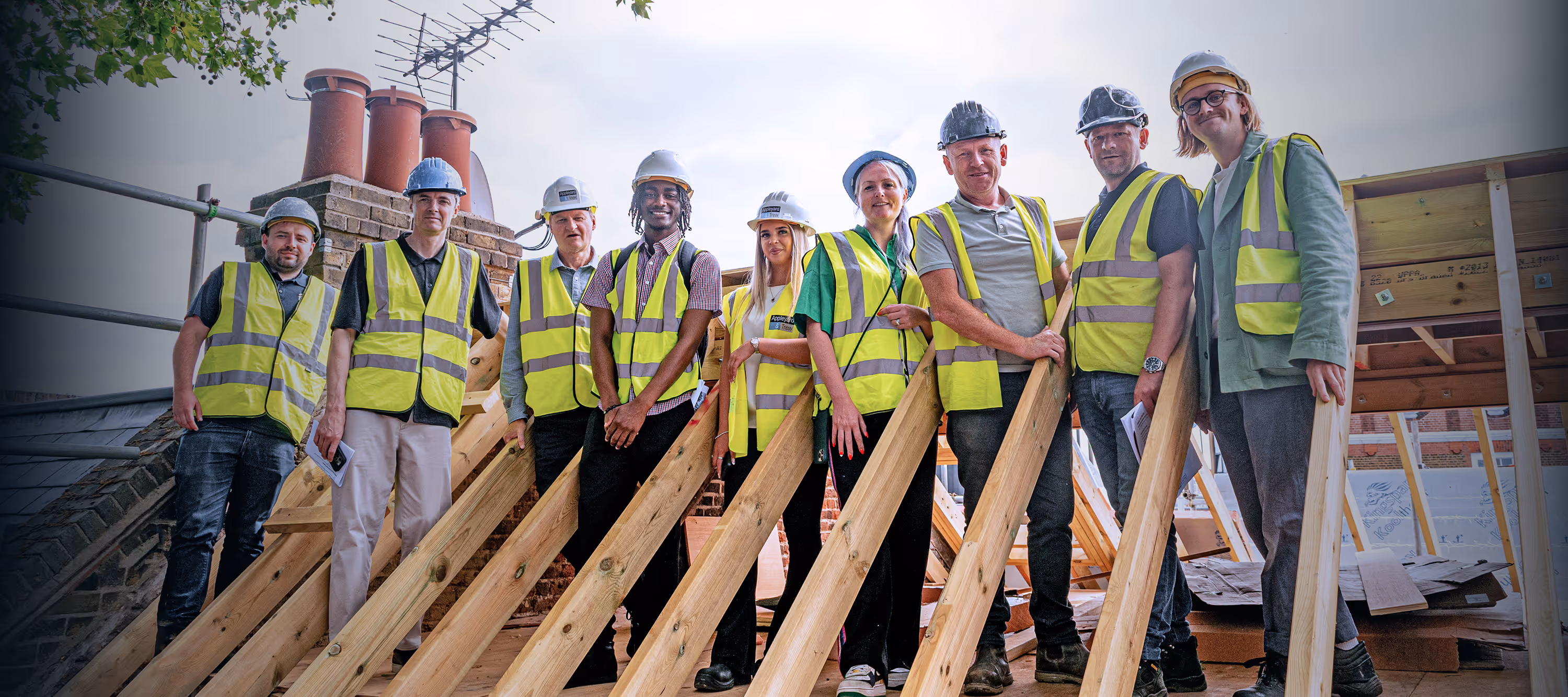 A group from the Anti-Apartheid Legacy Centre pose in the bare raftors of a building renovation project. The site will transform the former London HQ of ANC into the first anti-apartheid museum in Europe. Photo Credit: Al-Jawad Pike Architects.