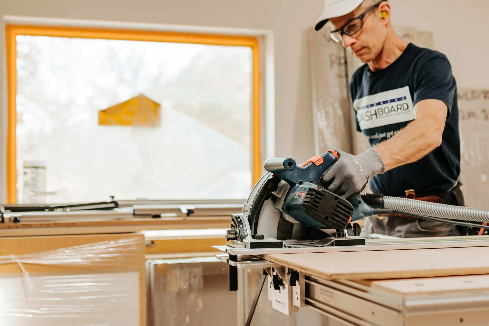 Man using a saw on a portable workbench