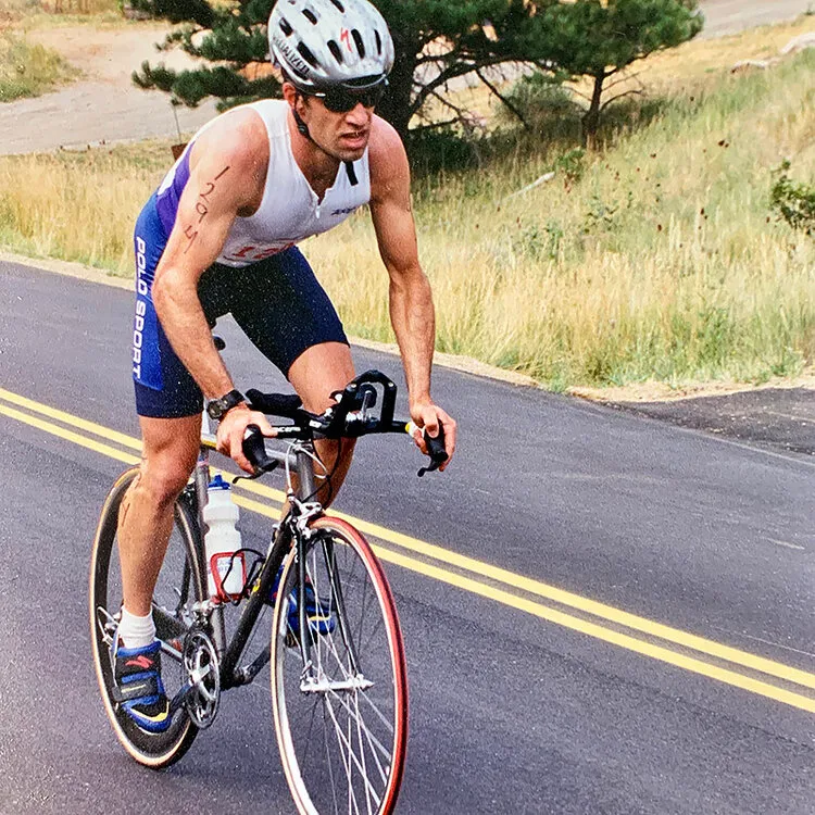 Man riding a road bike with a helmet on a road