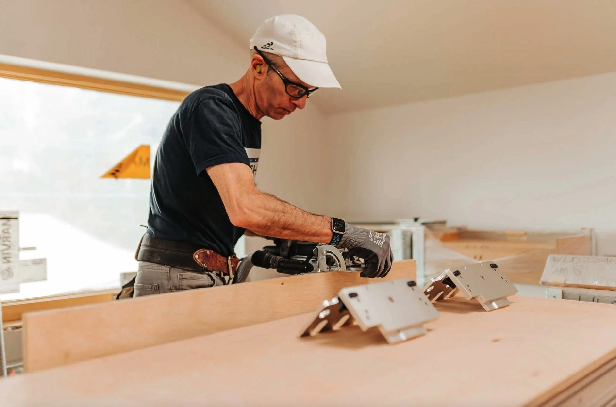 man using a saw on a workbench