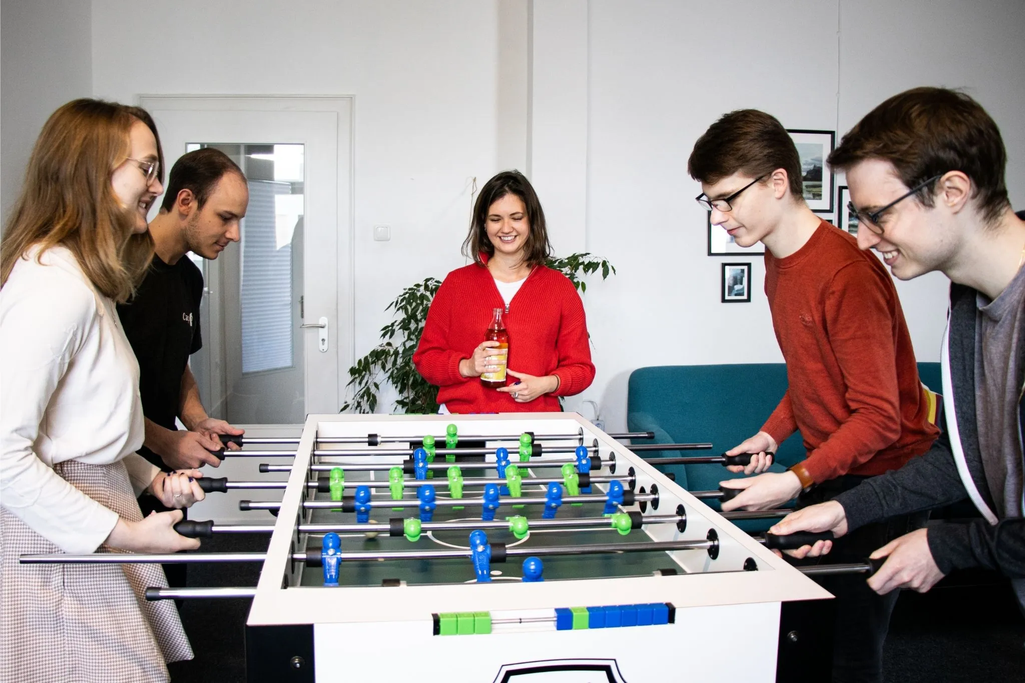 Eine Gruppe Werkstudenten, die in ihrer Pause gegeneinander Kicker spielen