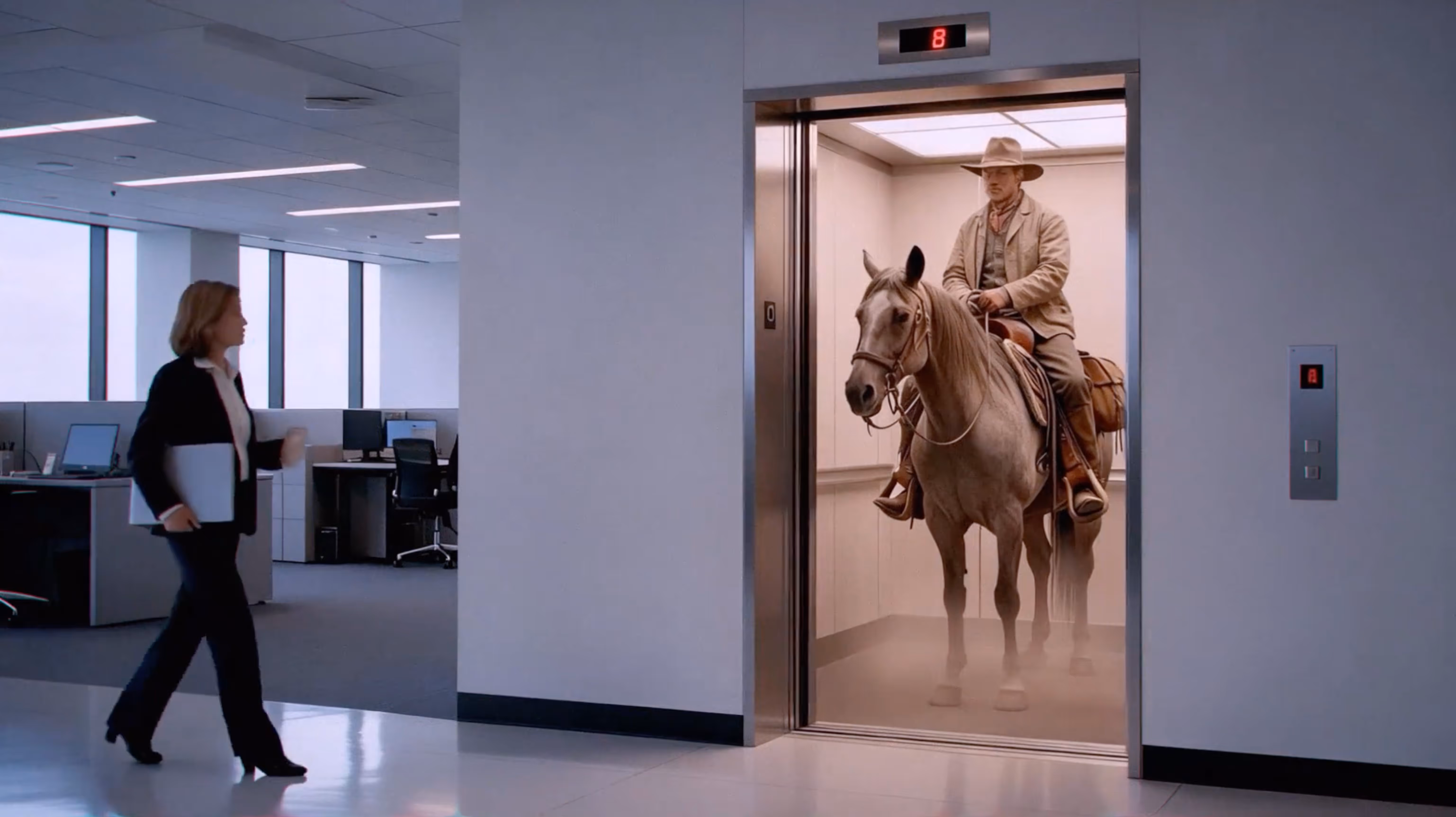 Man wearing cowboy attire riding a horse inside an office elevator while a woman walks nearby.
