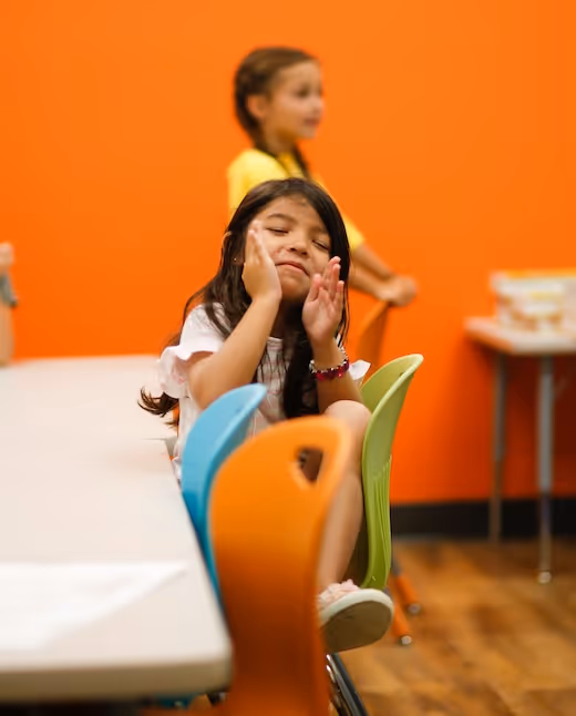 Tired student resting head on hand in colorful classroom setting