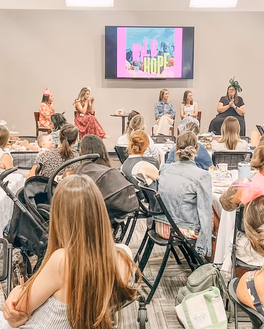 Women's conference with colorful "WILD HOPE" presentation on screen