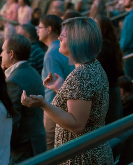 Crowd of people standing, woman in leopard print dress raised hands