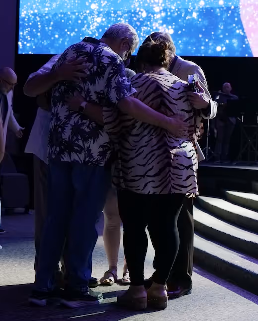 Two people hugging under starry background with blue lighting