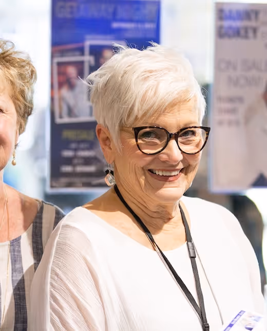 Smiling older woman with glasses at conference or event