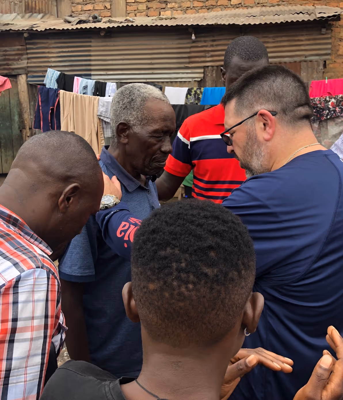 Group of men gathered closely together in informal outdoor setting