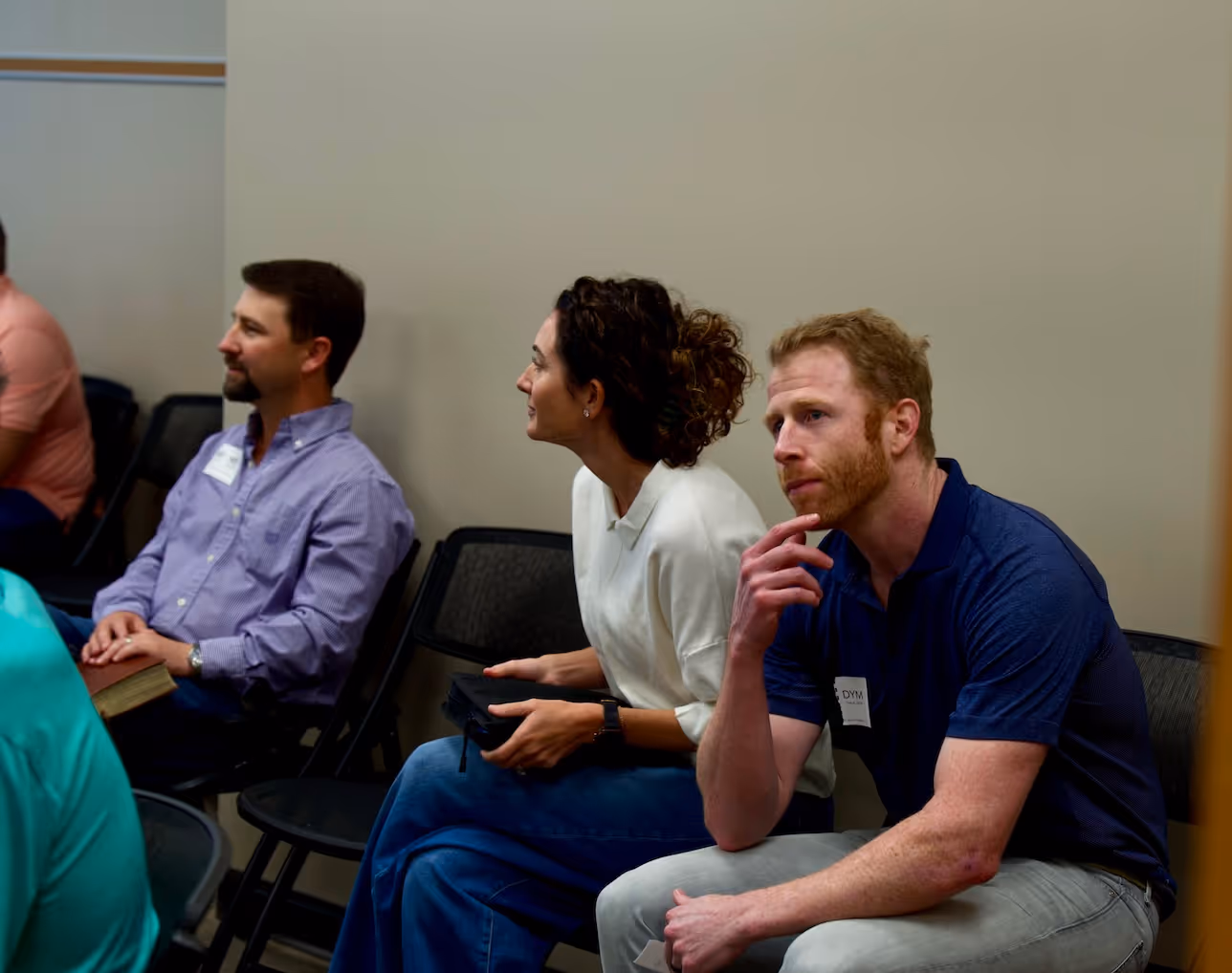 Three people sitting in chairs during a meeting or conference