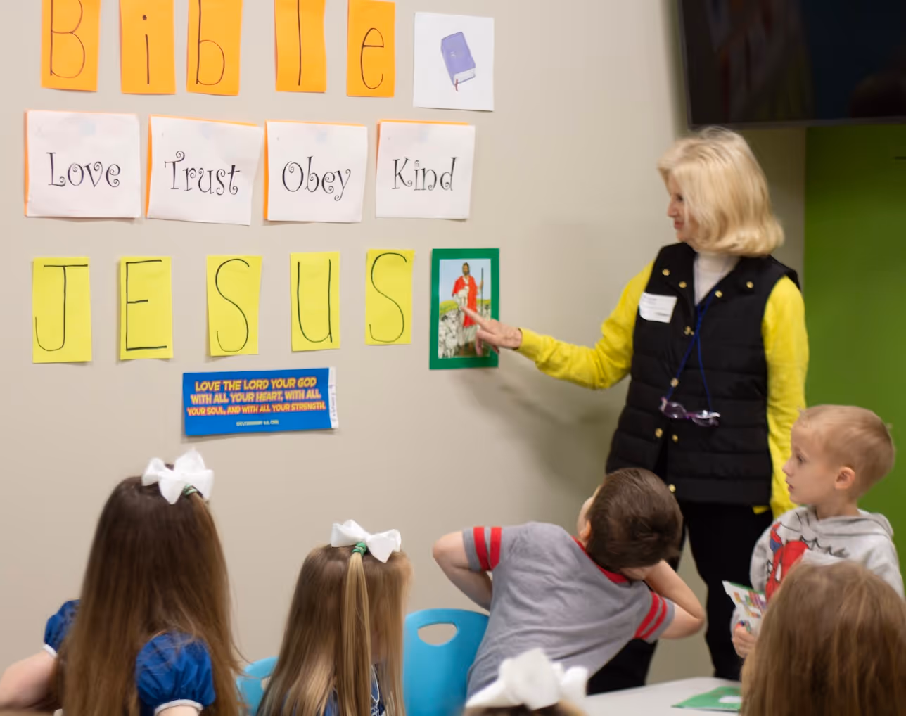Sunday school teacher presenting Jesus lesson with biblical values to children