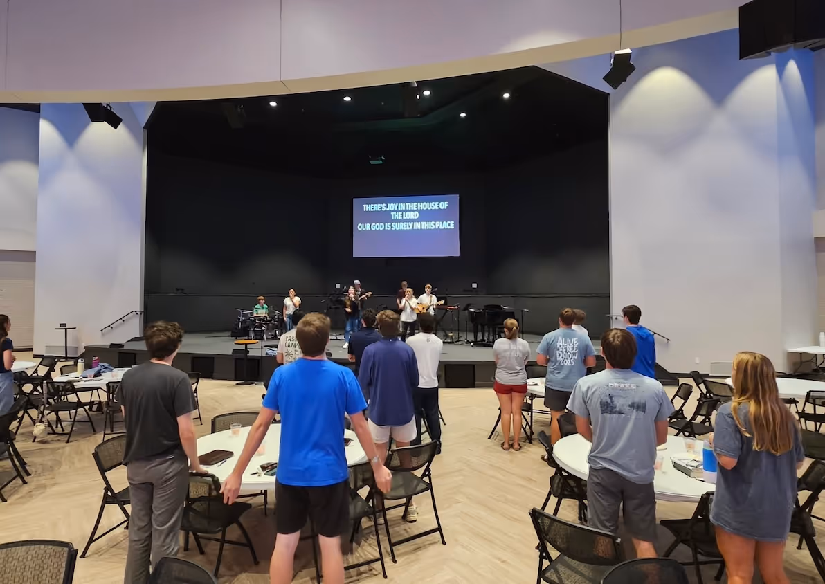 Worship band on stage with congregation standing during church service