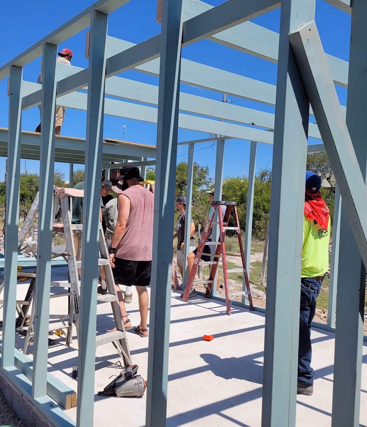 Construction workers building metal frame structure on sunny day