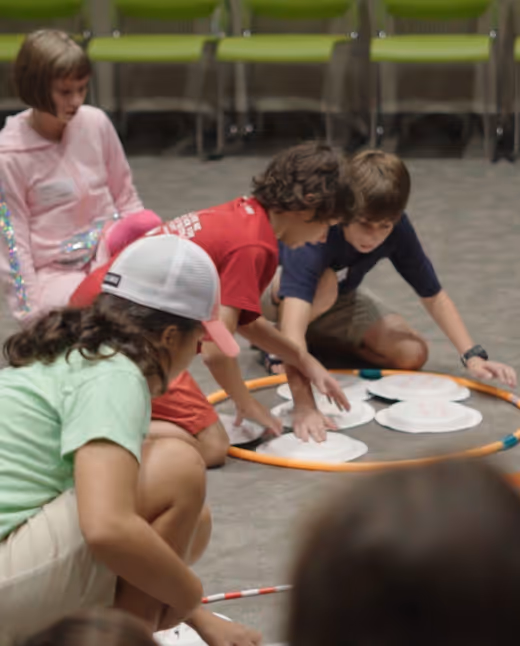 Children collaborating around circular table during interactive group activity