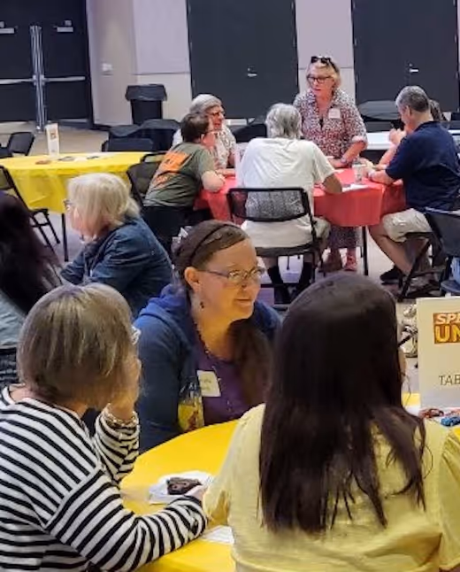 Singles ministry meeting with diverse adults gathered around colorful tables