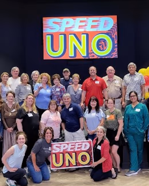 Singles ministry group poses with colorful Speed UNO game sign