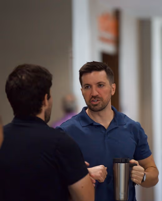 Two young men talking to one another in a hallway at FBC Covington