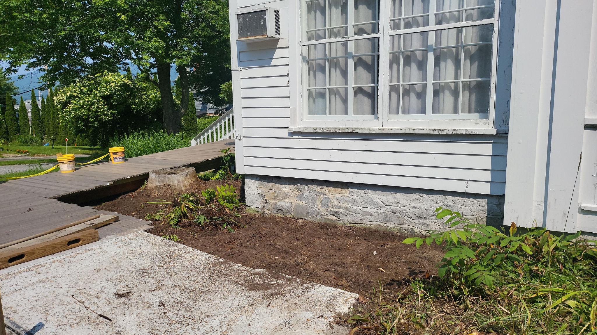 Dug up garden on side of building