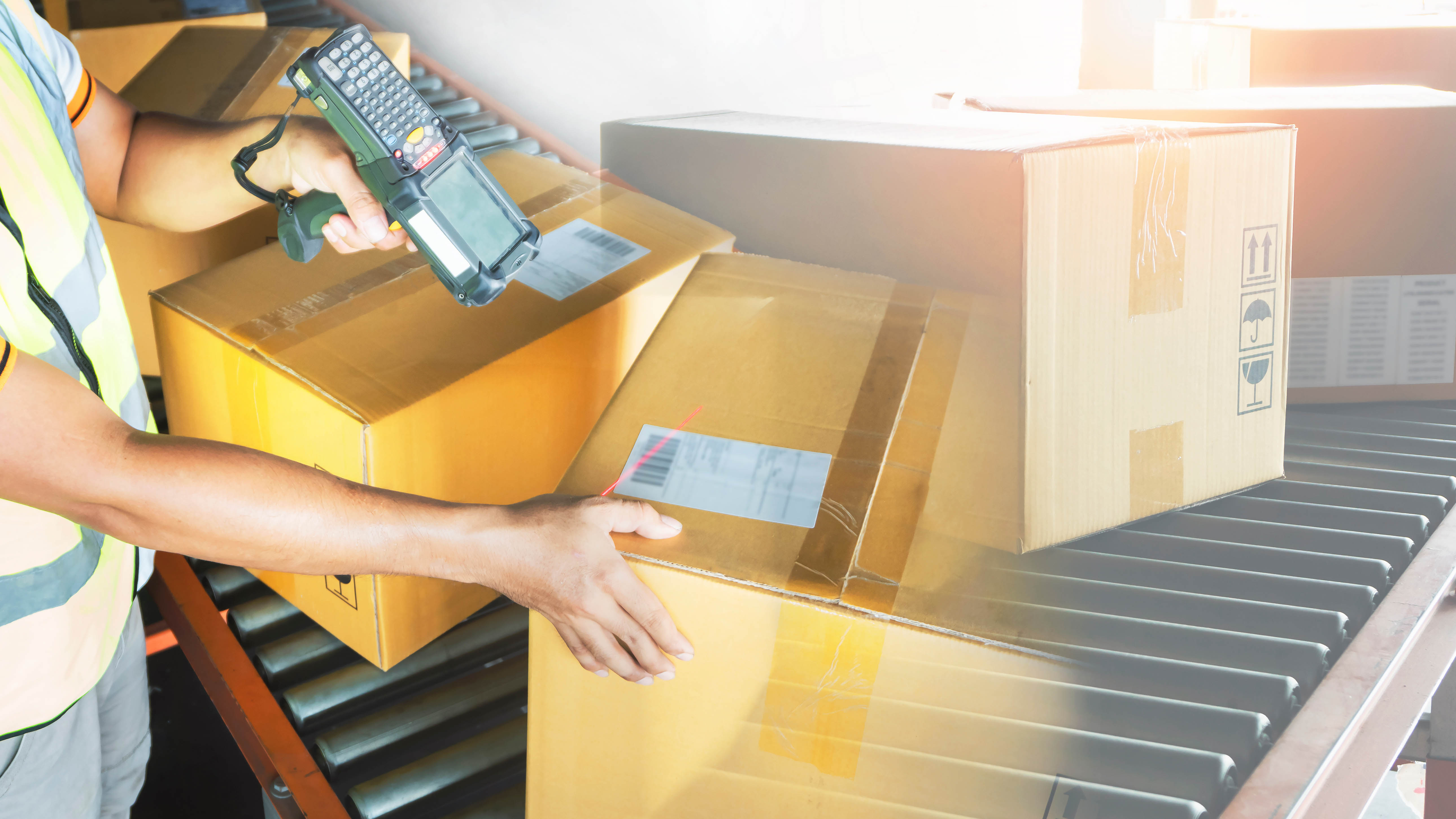 Warehouse worker scanning barcodes on incoming inventory boxes, illustrating Shopify's June 2026 purchase order and transfer receiving updates