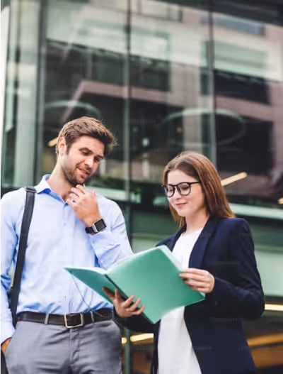 Deux collègues discutant devant un bâtiment d’entreprise, illustrant une recommandation professionnelle