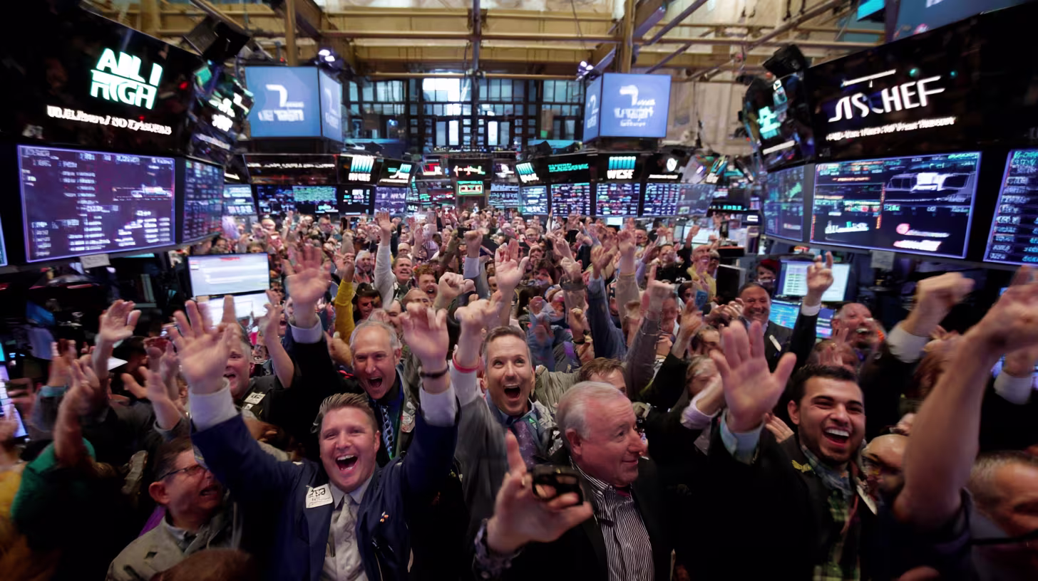 Wall Street traders on the stock exchange floor cheering and raising their hands as market screens display strong gains.