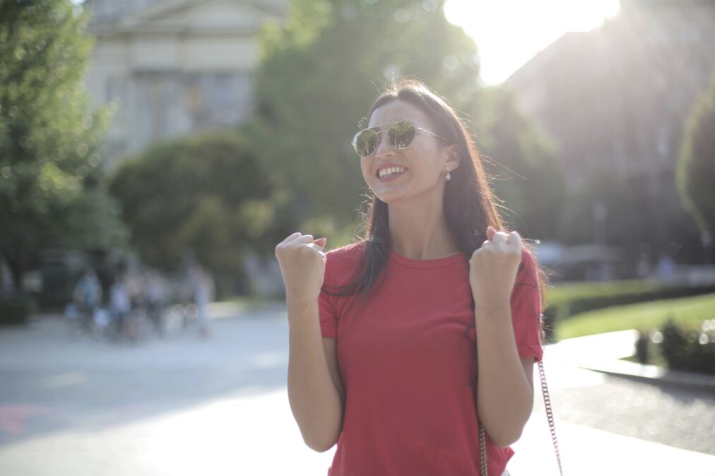 Woman outdoors, arms raised