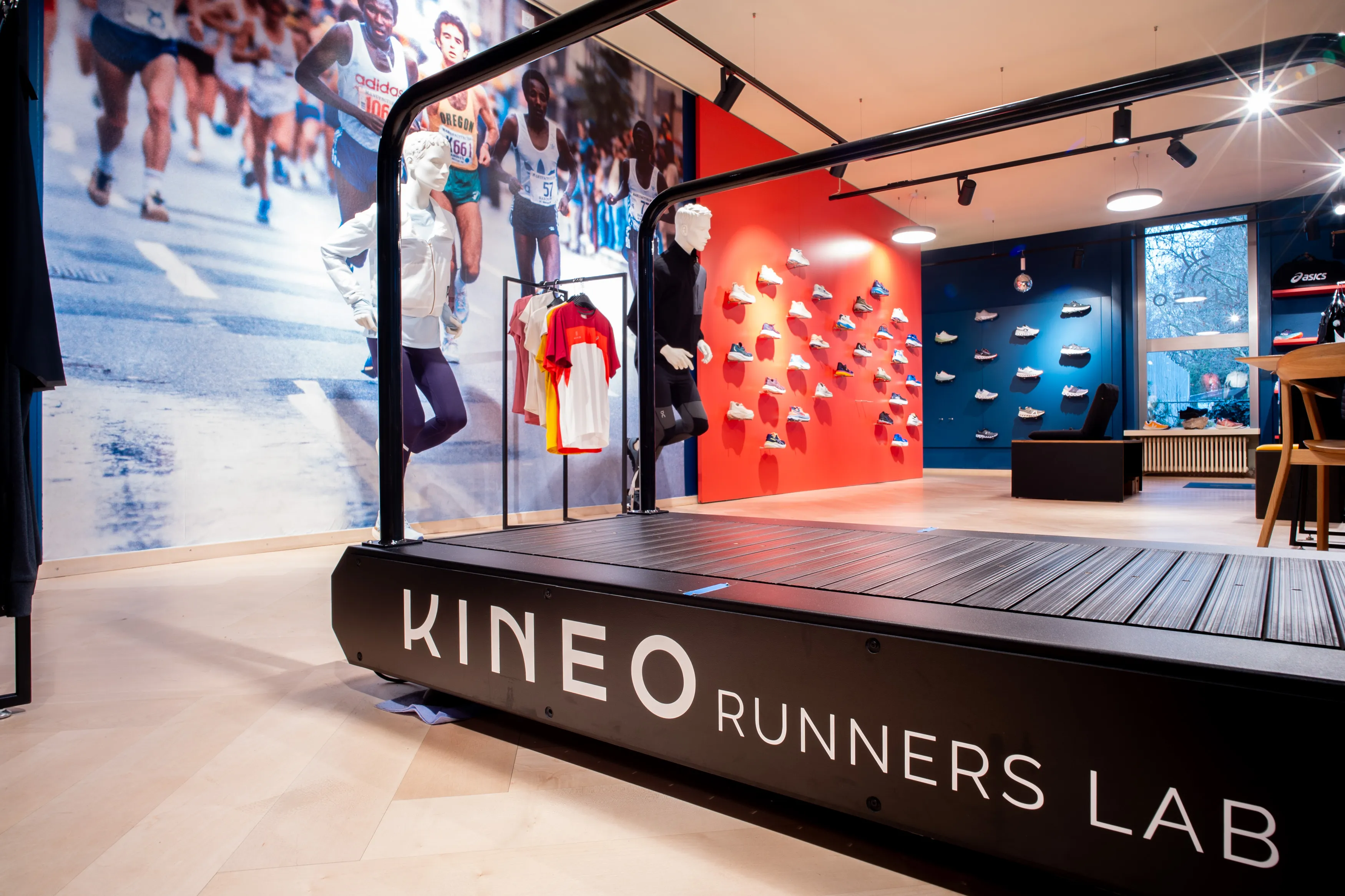 Runners Lab Seefeld mit Laufband und Schriftzug, roter Schuhwand, Marathon-Wandbild und Schaufensterpuppen