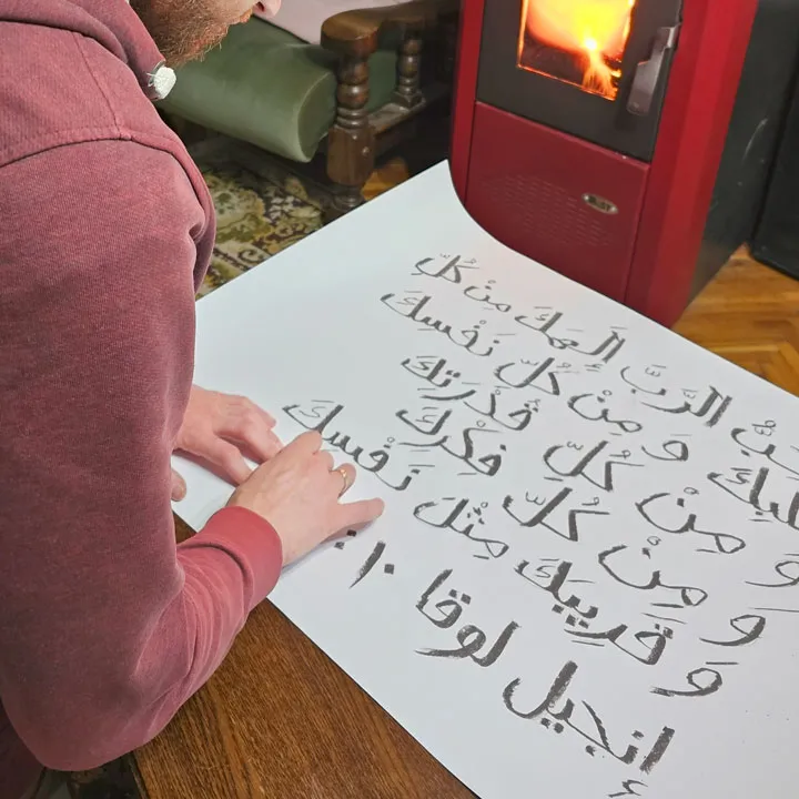 Writing Luke 10:27 in Arabic on a piece of paper