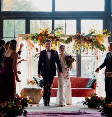 pasgetrouwd koppel wandelt rode loper na ceremonie wedding planner