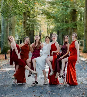 Bruid en trouwmeisjes to poseren in hun jurken