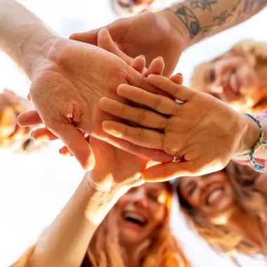 eventbureau leuven organiseert een teambuilding waarbij een groep teamleden de handen in elkaar slaat