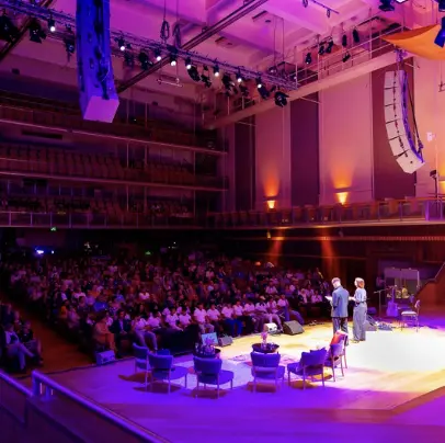 eventbureau leuven organiseert een congres in een professionele, gevulde congreszaal met een groot scherm