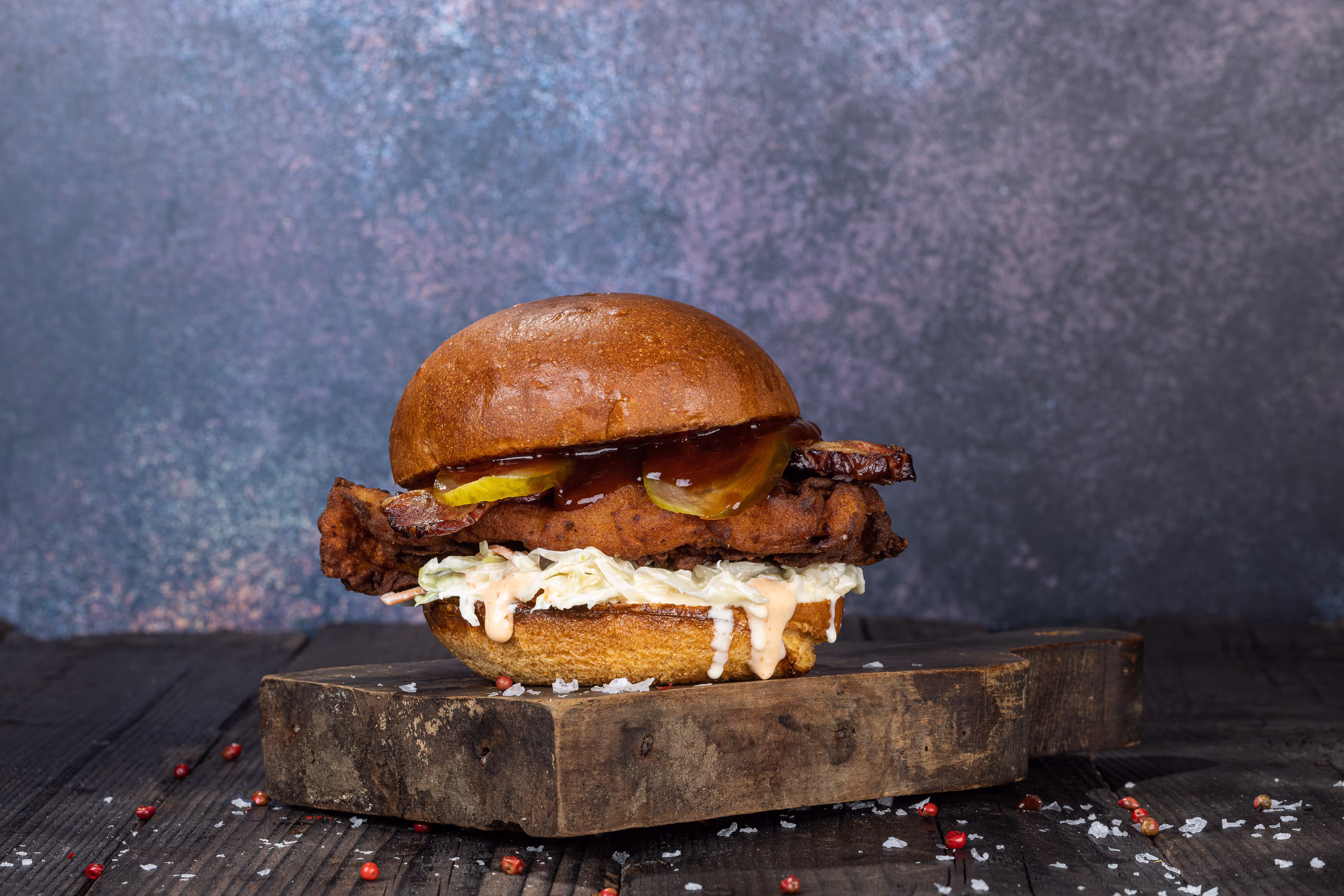 Burger cu carne de porc fragedă, sos BBQ, murături și salată.