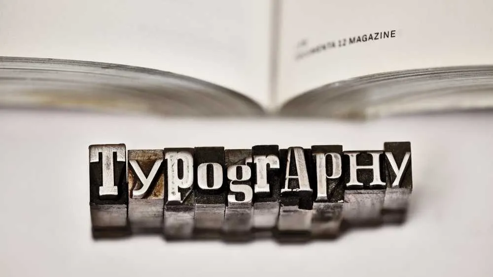 Printing blocks spelling typography beside an open magazine