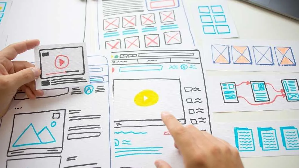 Designer reviewing paper interface layouts