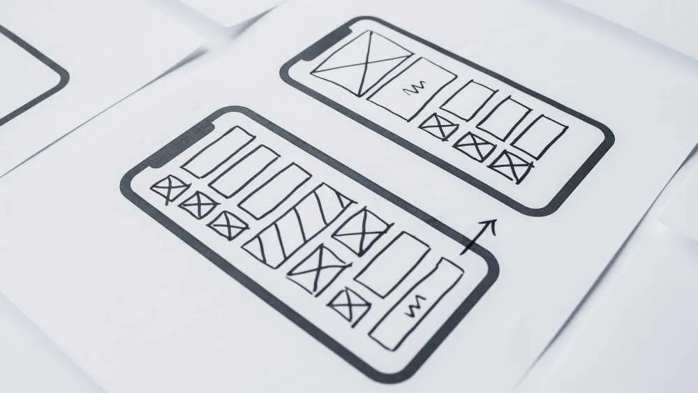 Paper mobile wireframes showing navigation and content blocks