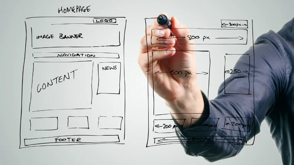 Website wireframe being sketched on a transparent surface