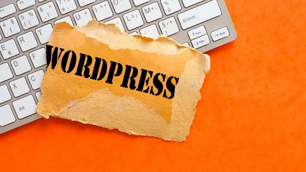 WordPress label beside a keyboard on an orange surface