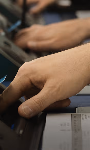 Main d'une personne utilisant un équipement électronique avec un ticket imprimé visible en bas.