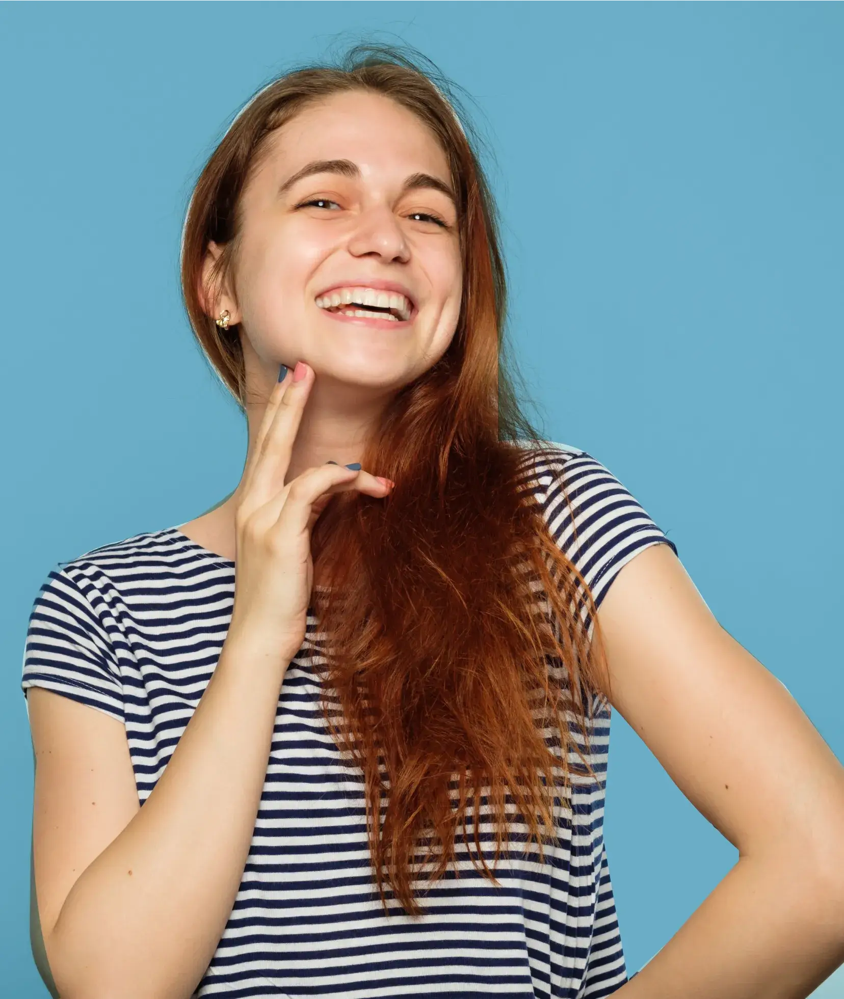 A woman with long red hair is smiling.