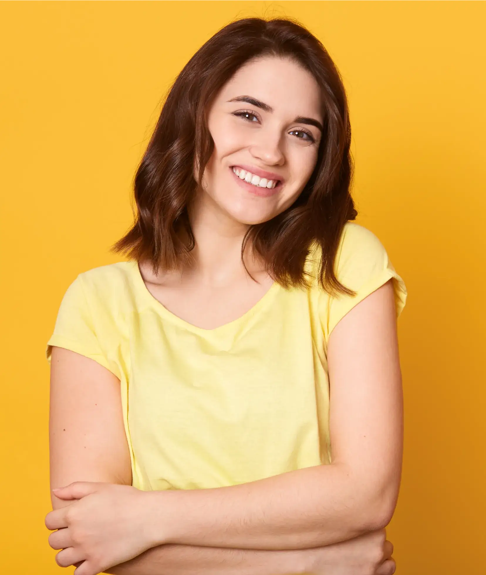 A woman with her arms crossed posing for a picture.
