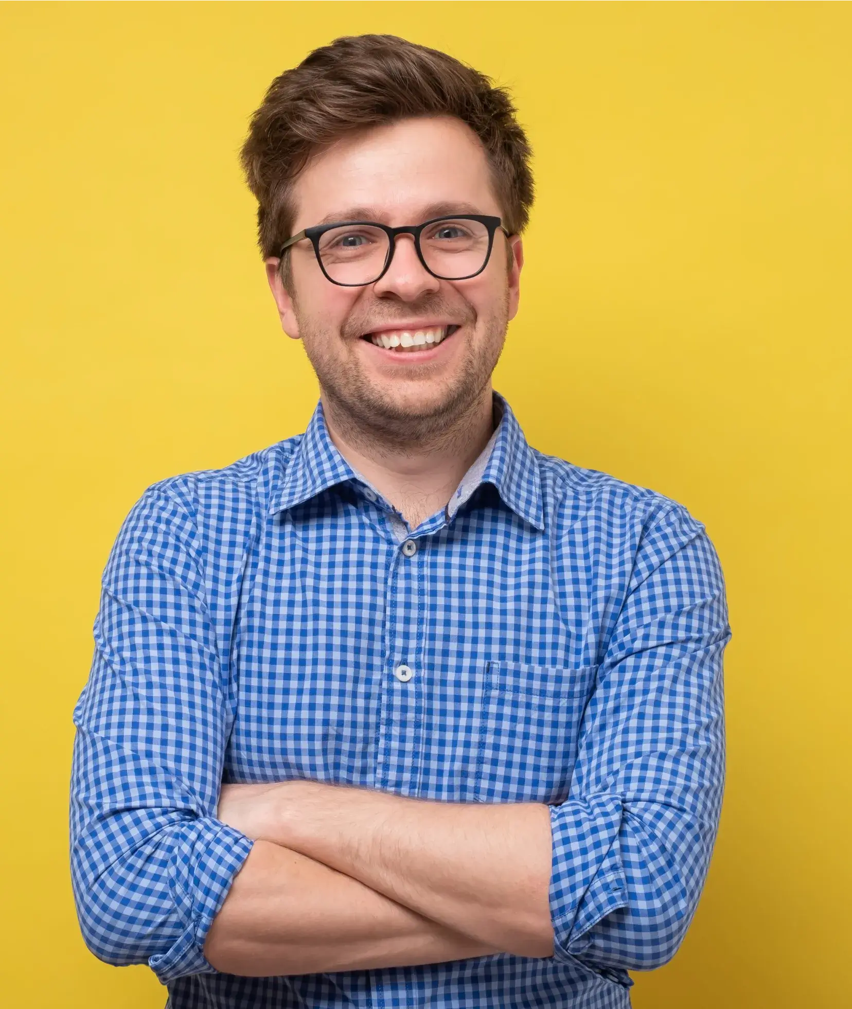 A man wearing glasses and a blue checkered shirt.