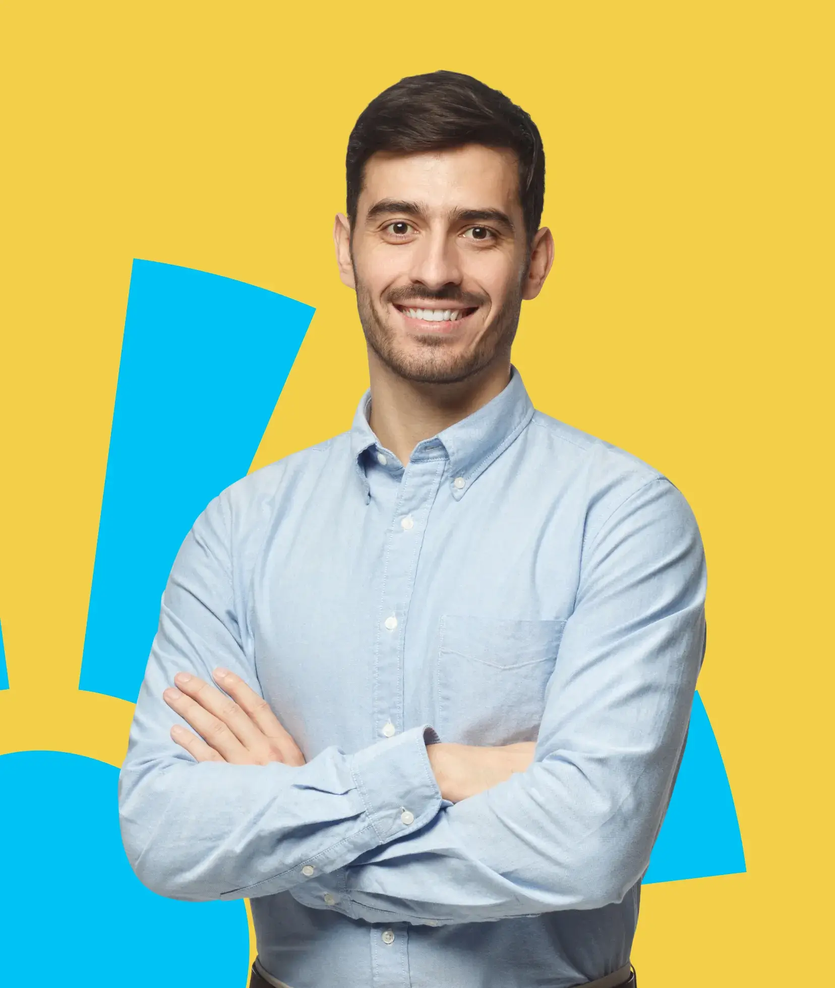 A man in a blue shirt smiling with crossed arms against a yellow background.