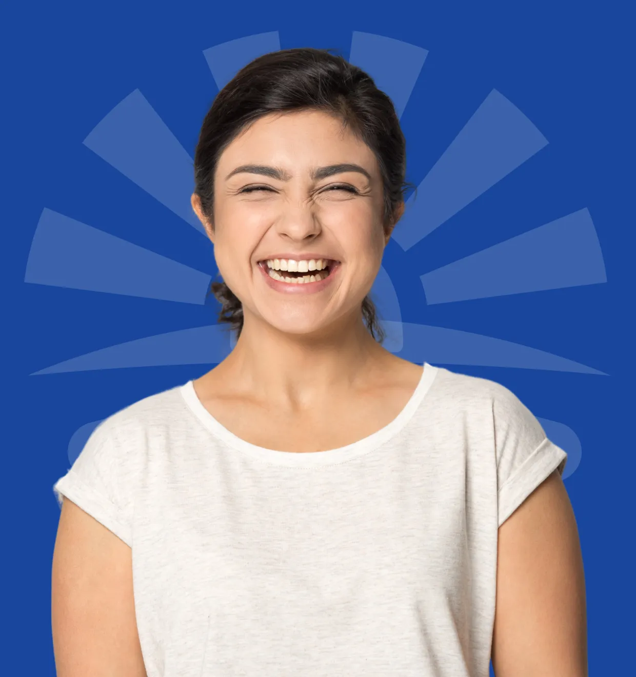 A woman in a white shirt smiles broadly against a blue background.