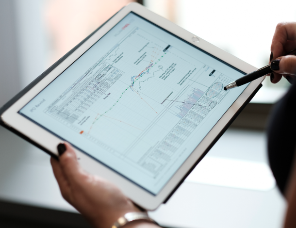 An image of someone holding an iPad with a William O'Neil + Co. Stock Chart.