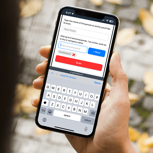 A person holding a mobile phone, filling out forms on the Gotchabot.ai form. The additional keyword input is currently selected. One additional keyword has already been added. 