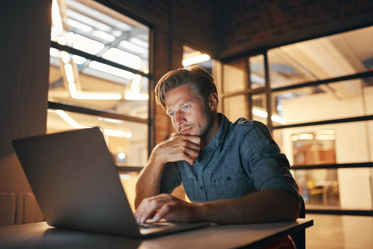 Man working at his computer looking curiously at his screen