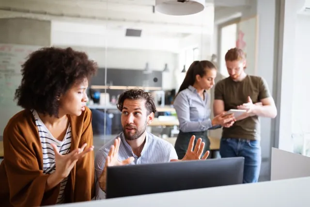 groups of people in an office space working together on a computer
